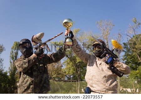Paintball players with guns and gold cup