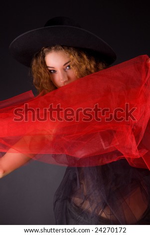 Sensual red-haired girl in hat, holding red scarf