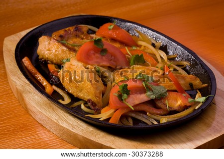 Roasted chicken with tomatoes, studio shot