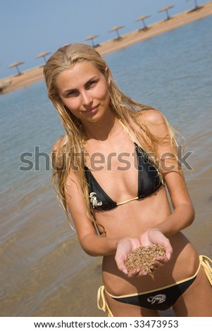 Girl on a coastline holding sand, closeup outdoor shot