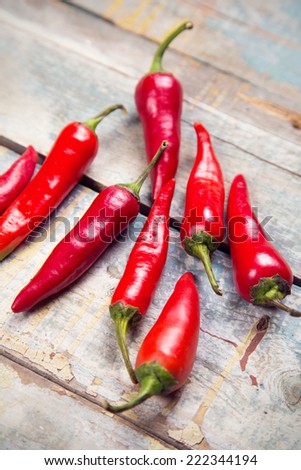 few ripe pods of very spice pepper are on a wooden background