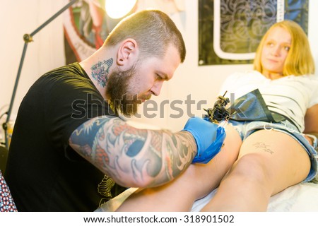 MINSK, BELARUS - SEPTEMBER 19, 2015: Professional tattoo artist doing tattoo on woman. The 2th International Tattoo Convention
