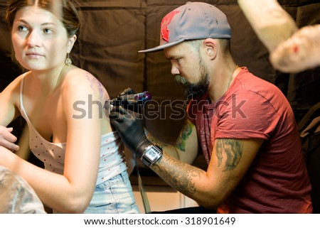 MINSK, BELARUS - SEPTEMBER 19, 2015: Professional tattoo artist doing tattoo on woman. The 2th International Tattoo Convention