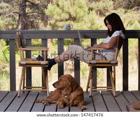 Woman relaxing with dog and laptop computer