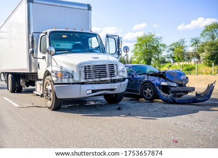 Collision of a semi truck with box trailer a passenger car on the highway road, as a result of which both cars were damaged, await the arrival of the police to draw up an accident report