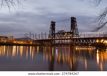 Colorful landscape panorama night Portland office buildings and silhouette with a drawbridge across the river Willamette burning reflection sets evening city lights on the surface of a quiet water.