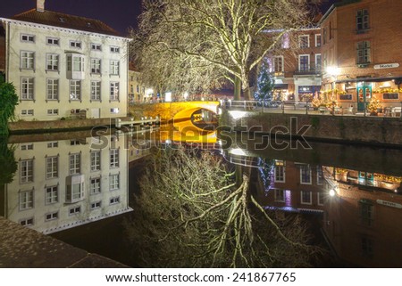 Bruges, Belgium - December 28, 2014: Green canal in Bruges. One of the most visited tourist attractions.
