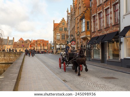 Bruges, Belgium - December 25, 2014: Horse-drawn carriage on the ancient streets of Bruges. Popular activities among tourists.
