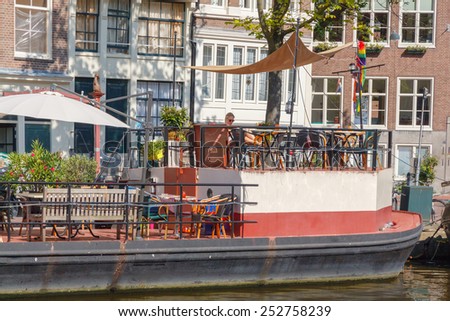 Amsterdam, Netherlands - August 5, 2014: Traditional house boat on the canals of Amsterdam. In Amsterdam, there are about 2,500 homes on the water.