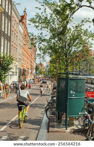 Amsterdam, Netherlands - August 3, 2014: People moving to Amsterdam on bicycles. Most popular transport in the Netherlands.