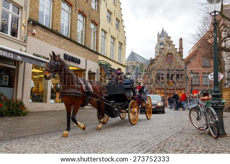 Bruges, Belgium - December 26, 2014: Horse-drawn carriage on the ancient streets of Bruges. Popular activities among tourists.