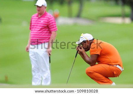 NAKHONPATHOM,THAILA ND - AUG 9:Chapchai Nirat (R) of THA  lines up prior to putting during hole9 day one of the Golf Thailand Open at Suwan Golf&Country Club on August 9, 2012 in Nakhonpathom Thailand