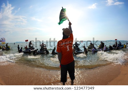 PATTAYA CITY THAILAND-DECEMBER 7:Unidentified The Official show the green flag start  class Pro-Am Runabout Open the Jetski  King\'s Cup World Cup Grand Prix at Jomtien Beach on Dec7, 2012 in,Thailand.