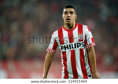 BANGKOK,THAILAND-JANUARY 8:Zakaria Bakkali (red) of PSV in action during The AIA Champions Cup match between SCG Muangthong Utd. and PSV at SCG Stadium on Jan8 ,2012 in ,Thailand.