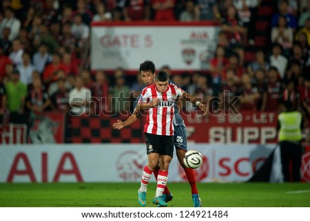 BANGKOK,THAILAND-JANUARY 8:Zakaria Bakkali (red) of PSV in action during The AIA Champions Cup match between SCG Muangthong Utd. and PSV at SCG Stadium on Jan8 ,2012 in ,Thailand.