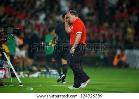 BANGKOK,THAILAND-JANUARY 8:Coach	Dick Advocaat (RED) of PSV in action during The AIA Champions Cup match between SCG Muangthong Utd. and PSV at SCG Stadium on Jan8 ,2012 in ,Thailand.