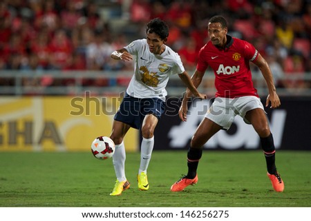 BANGKOK,THAILAND-JULY13:Teerasil Dangda(L)of Singha All Star XI in action during the friendly match between Singha All Star XI and Manchester United at Rajamangala Stadium on July13, 2013 in Thailand.