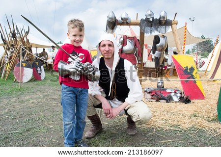 CREVALCORE,ITALY-MAY 4,2013:actors dressed in medieval clothes show to a child how to use the sword