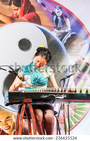 PADOVA,ITALY-DECEMBER 8,2014:An oriental woman with traditional costumes plays the koto during a perform inside an event called Festival of East which takes place in the Italian city of Padua