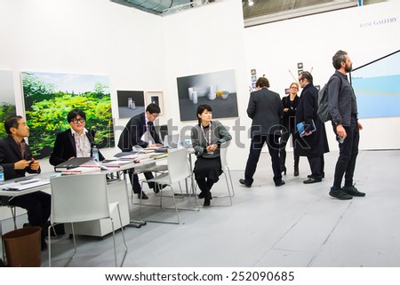 BOLOGNA,ITALY-JANUARY 24,2015:people walk and look at works of art in an exhibition while art experts answer all questions related to the artists on display.