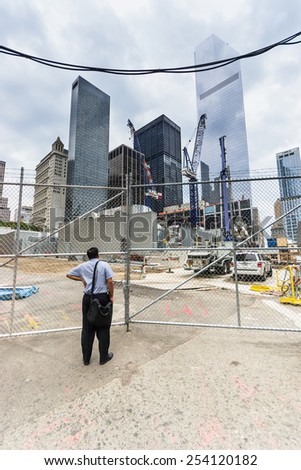NEW YORK CITY,USA-AUGUST 2,2013:a person admires the construction site of World Trade Center tower over Ground Zero Lower Manhattan  through the intersection of Albany and Greenwich Streets.