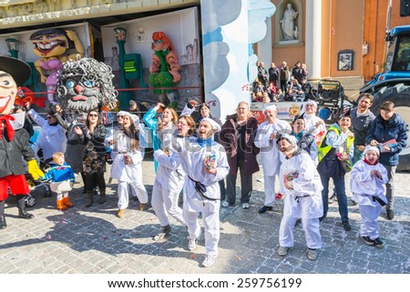 SAN GIOVANNI IN PERSICETO,BOLOGNA,ITALY-MARCH 7,2015:funny people in colored carnival costume and masks celebrate at the traditional carnival of san giovanni in persiceto during a sunny day.