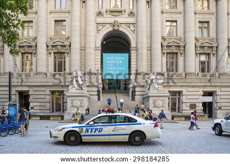 NEW YORK CITY,USA-AUGUST 6,2013:a police car parked in front of the new york national museum of the american indian while people come to visit