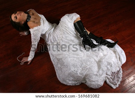 a woman on a stained floor in a wedding dress