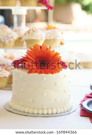 a cake with cupcakes in the background at a wedding