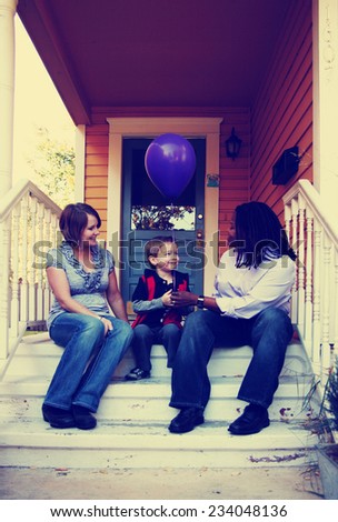 a cute family sitting on a porch toned with a retro vintage instagram filter