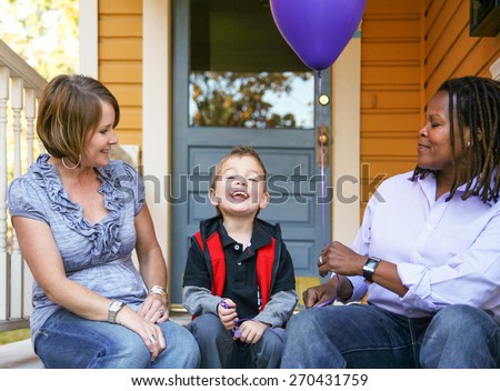 a cute diverse family sitting on a porch