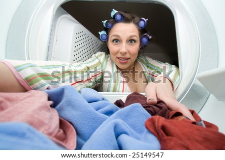 a woman reaching in the dryer for clothes - domestic series