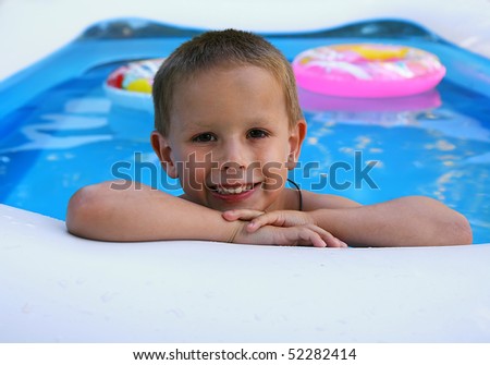 a young boy swimming in a small pool