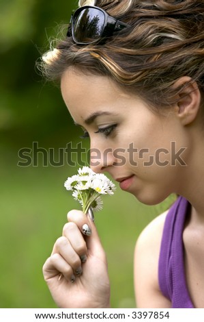pretty girl smells white flower in nature