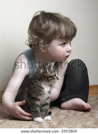 little adorable boy and kitten playing at home