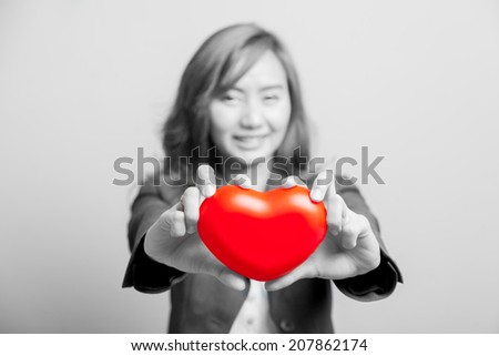 Asian girl show red heart with both hand  focus at the heart on black and white