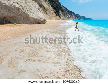 Girl have the water-based recreation on white beach near azure Ionian sea (Egremni, Lefkada, Greece)