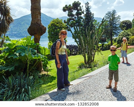 Family in summer park with cactus plants and Como Lake behind
