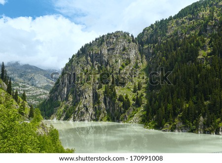 Lake  with turbid water formed the dam. Summer mountain landscape (Alps, Switzerland)