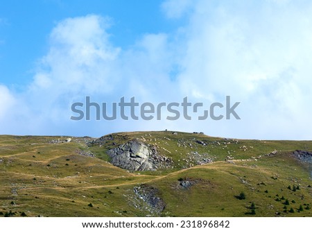 Summer view from Transalpina road (Southern Carpathians,  Romania) with flock of sheep on slope.