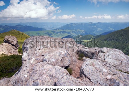 big stone with hollow of big foot form on summer mountain background