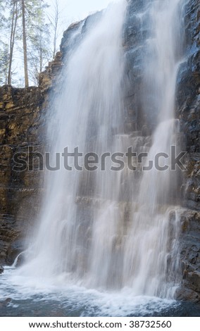 High mountain waterfall in dark wild Carpathian forest. Three shots stitch image.