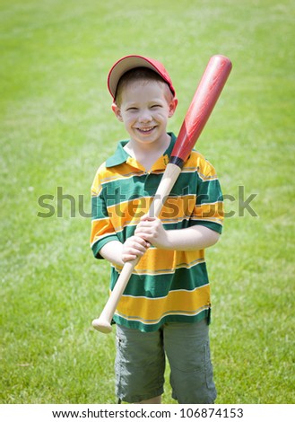 Cute boy with big smile outdoors on with baseball bat portrait