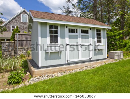 New blue garden shed in beautiful garden