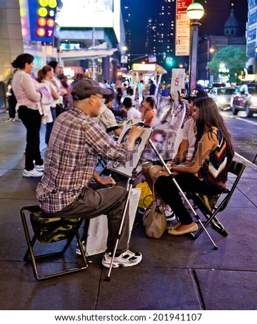 NEW YORK, USA - JUNE 28th 2014: Street artist drawing a young couple on 42nd Street in the busy theater district.