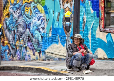San Francisco, USA - June 22nd, 2015: Man who appears to be experiencing hard times sitting on street ground in Chinatown in San Francisco
