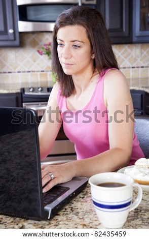 Woman in pink top working on her laptop computer