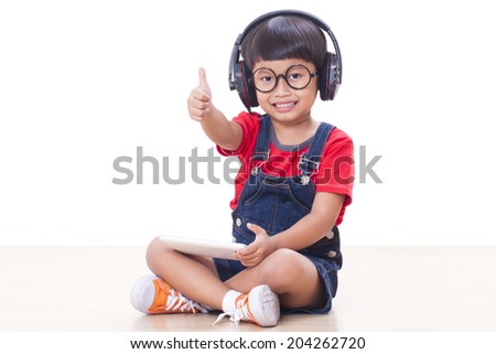 Happy boy with headphones connected to a tablet to listen to music
