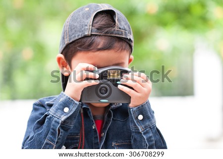 Cute boy using compact camera.
