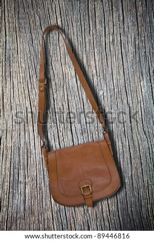 Brown women leather bag on wood ground
